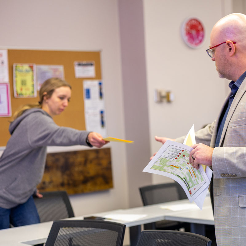 Student handing a pencil back to a professor.