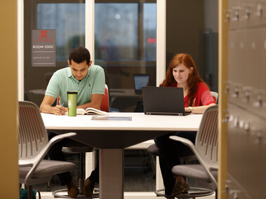 Students working on assignments in study space.