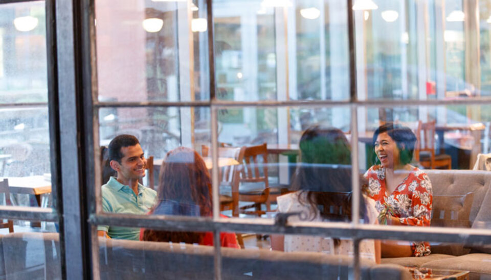 Graduate students sitting in dining hall.