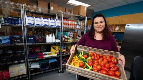 woman holding vegetables at the Husker Pantry