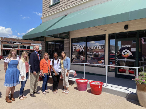 Rural Fellows Alicia Pannell (left), Tori Pedersen (second from left) and Janet Kabetesi (fifth from left) and community fellows Andrea McClintic (fourth from left) and Stephanie Novoa (right) are pictured with Lt. Gov. Mike Foley (third from left) at the Fox Theater ribbon cutting in Cozad.