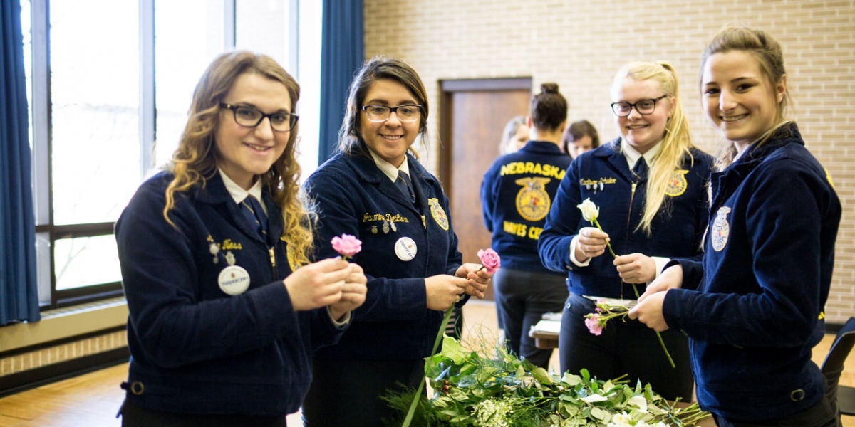 Nebraska CDE - Registration students holding long stem roses
